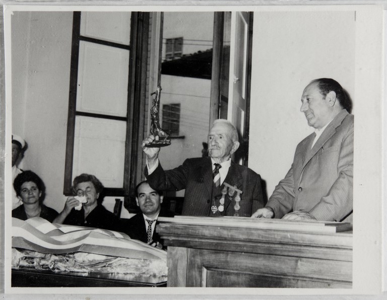 Poggibonsi, 18-19 luglio 1964, XX° anniversario della liberazione e conferimento ad Alcide Cervi della cittadinanza onoraria. Un momento della cerimonia, Alcide Cervi mostra una statuetta ricevuta in dono